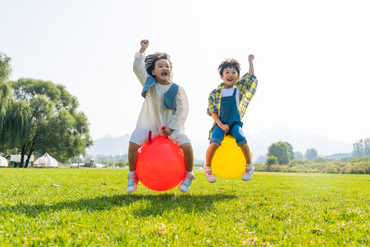 两个小孩在草地上做游戏