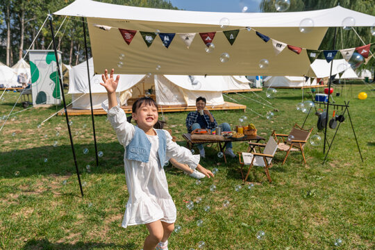 一家人在露营地天幕下玩耍