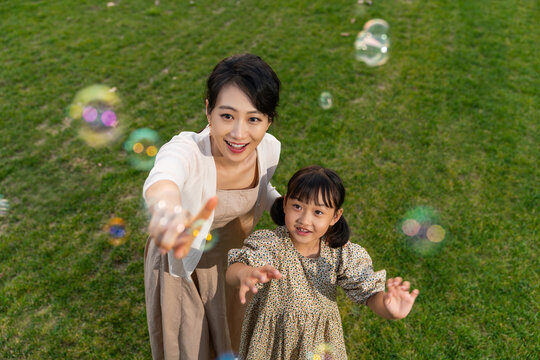 妈妈和孩子在草地上开心玩耍