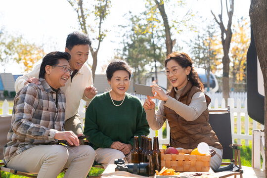 一群中老年人在房车露营地看手机视频