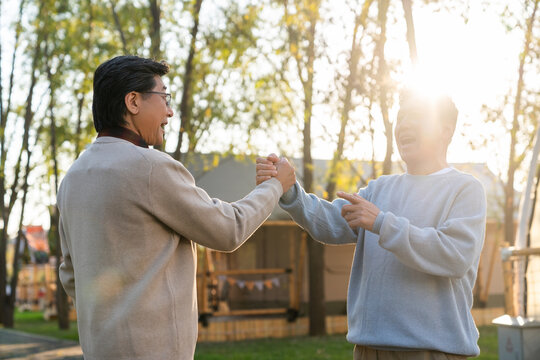 两个中老年男人开心地握手