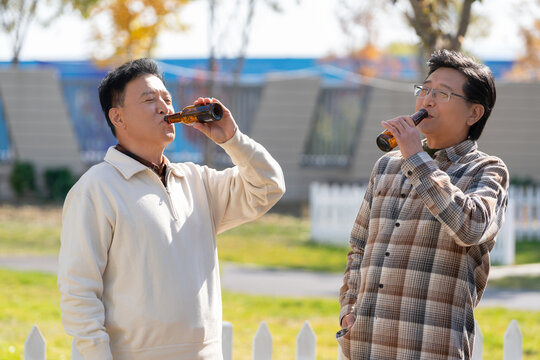 两个老年男人坐在营地喝啤酒