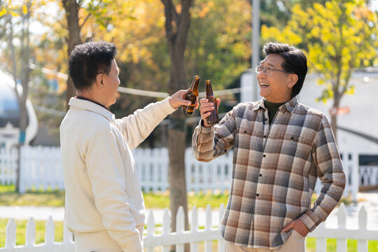 两个老年男人站在露营地喝啤酒