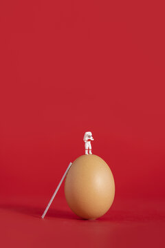 太空人与鸡蛋创意红色背景