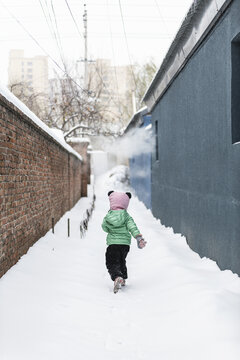 冬天在雪地小胡同奔跑的孩子