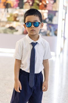 一个穿校服戴墨镜装酷的小男孩