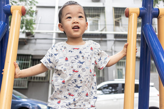 一个小男孩在院子里玩健身器械