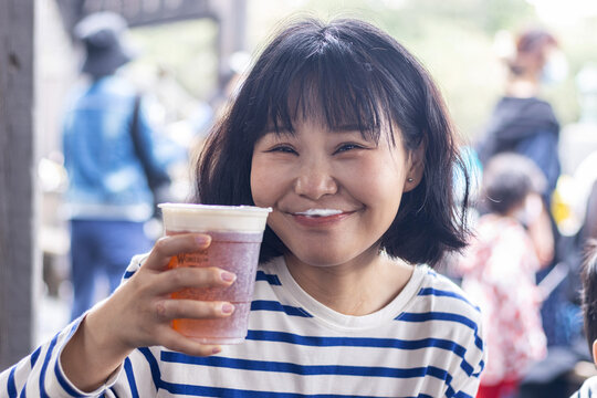 快乐的年轻女人举着一杯啤酒