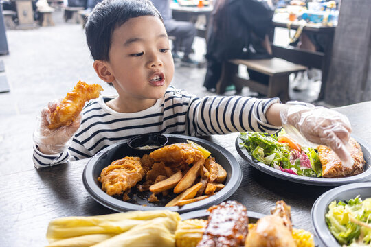 小男孩满足地吃炸鸡薯条