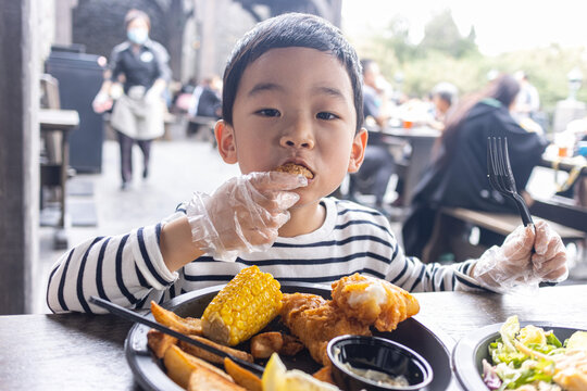 小男孩满足地吃炸鸡薯条