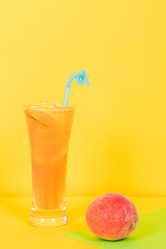 一杯冰爽橙汁与一个桃子