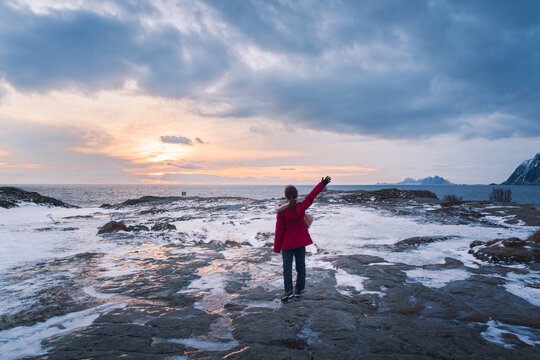 一名女性站在海边的雪地上