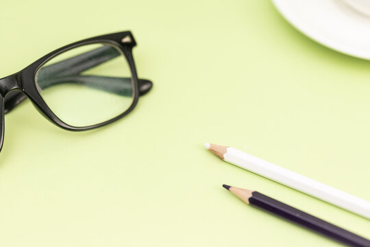 绿色背景上的铅笔与眼镜
