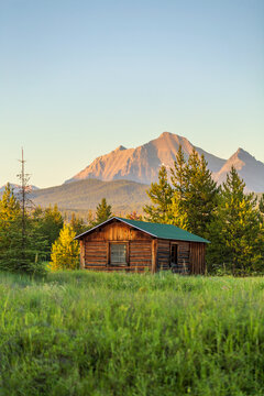 落基山脉的原木小屋和山峰背景