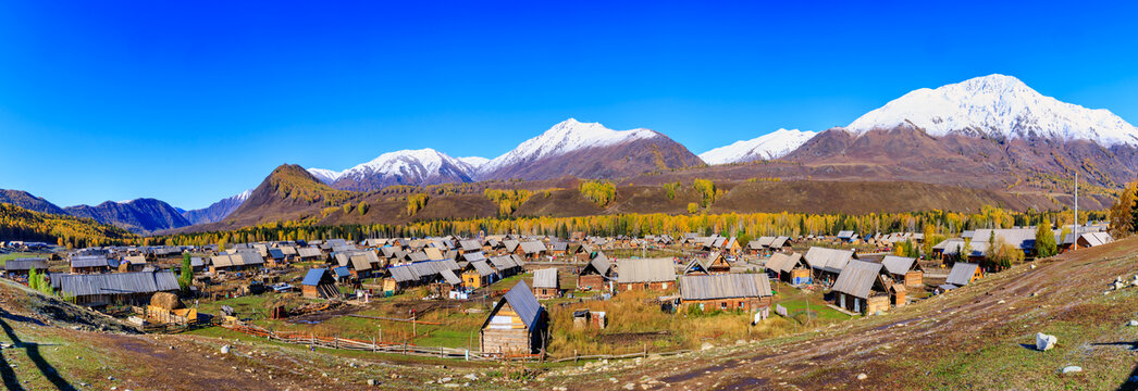 新疆禾木乡村小木屋雪山全景