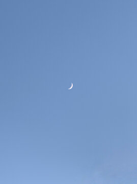 蓝色天空中央有一轮弯月