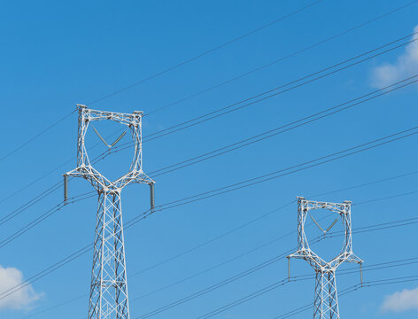 蓝天下电力铁塔的低角度视图