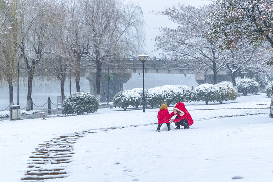 两位红色衣服小孩公园玩雪