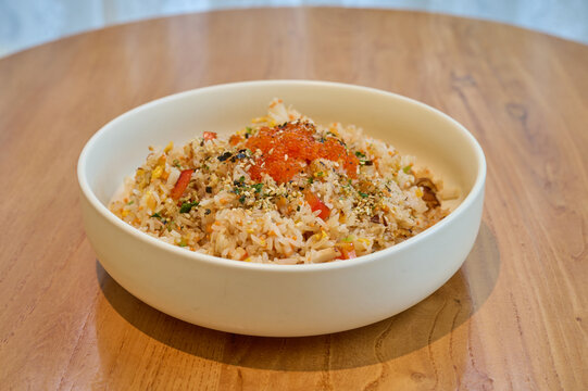 原木桌上一碗日式海鲜蟹子炒饭