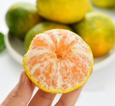 手拿一个橘子