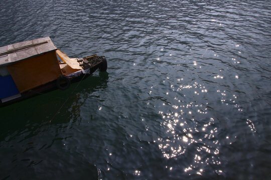 波光粼粼的水面上漂着小船