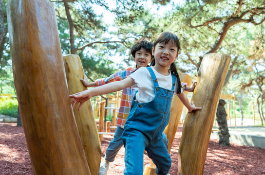 两个小孩子一起走木桩