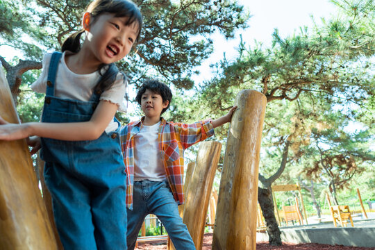 两个小孩子一起走木桩