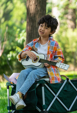 男孩坐在露营车上弹吉他