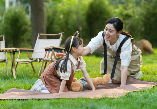 孩子和父母一起铺餐布准备露营装备