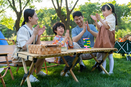 一家四口在露营地玩游戏开心欢呼庆祝