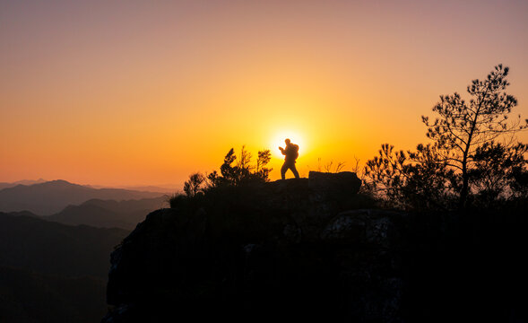一个人徒步爬山日落夕阳剪影景象