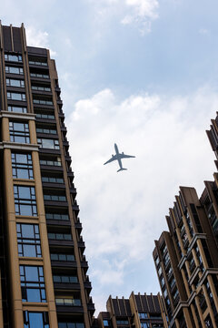 天空飞机低空飞行与地面住宅建筑