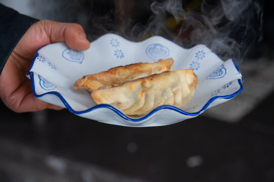 手里端着一盘煎饺常德锅饺