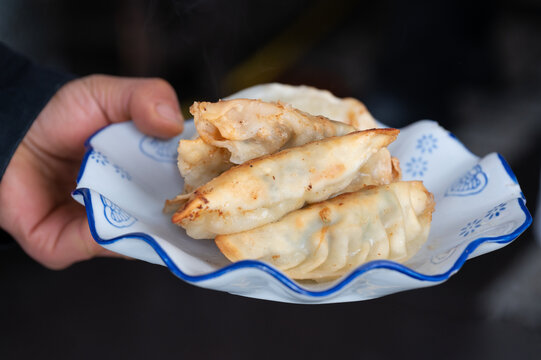 手里端着一盘煎饺常德锅饺