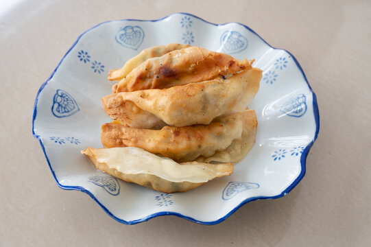 浅色桌面上一盘锅饺煎饺特写