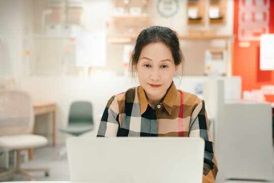 中年女性在笔记本电脑前办公场景