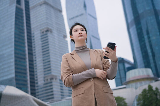 办公楼外自信女性查看手机