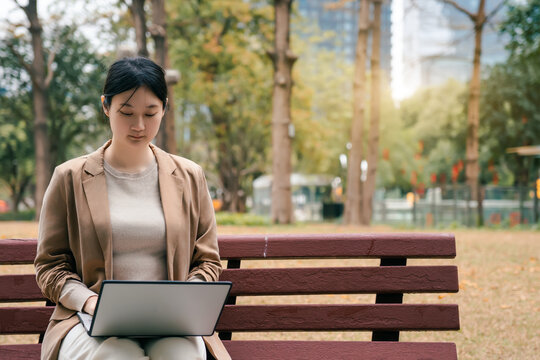 职业女性在公园长登上使用电脑