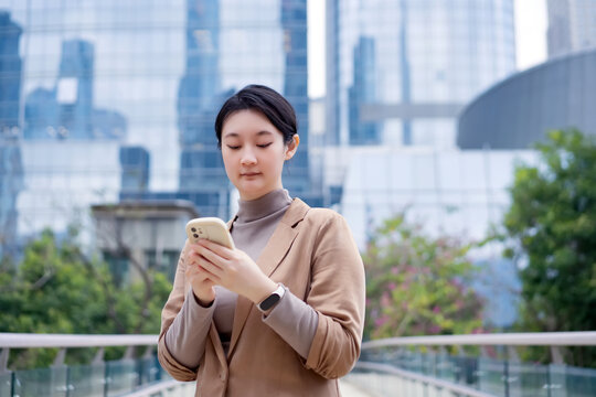 办公楼外职业女性查看手机