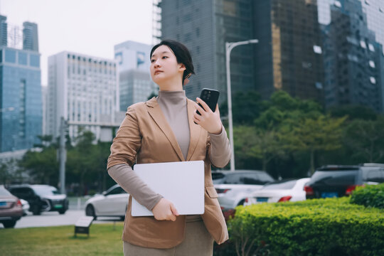 户外女性手持电脑多任务处理