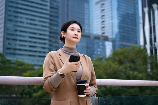 户外自信女子手拿智能手机