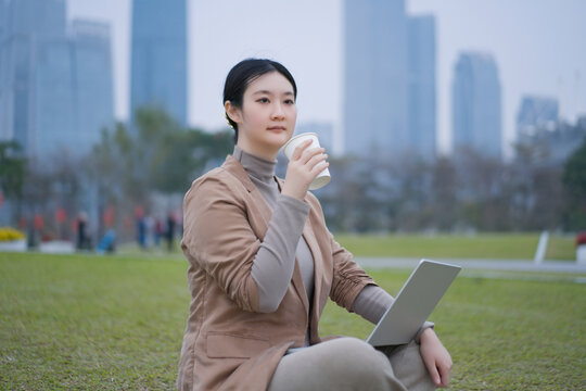 自信女性在户外拿着平板喝咖啡