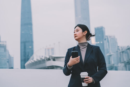 职业女性在户外中喝咖啡和打电话