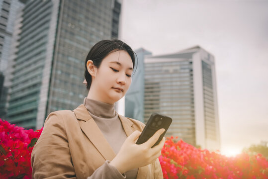 在户外花丛中查看手机的赋权女性