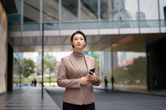 自信女子在城市里拿着智能手机