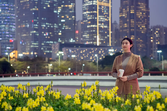 在夜晚城市花园里漫步的职业女性