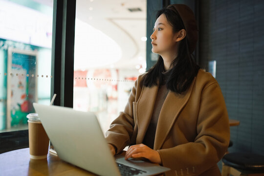 在咖啡店用笔记本办公的都市女性