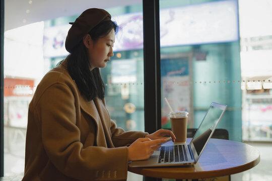 年轻女性在咖啡店移动办公