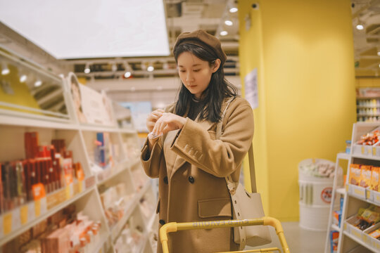 在超市货架上尝试商品体验的女子