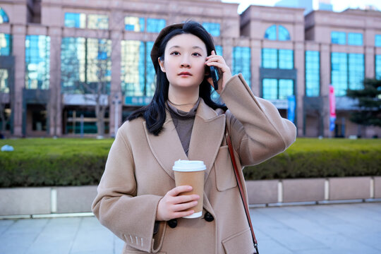 年轻女性在城市景观中打电话